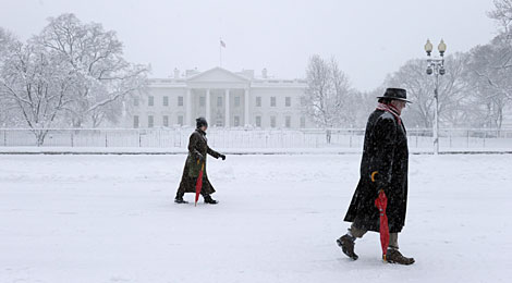 Dos personas pasan ante la Casa Blanca, cubierta por la nieve. | AP Dos personas pasan ante la Casa Blanca, cubierta por la nieve. | AP