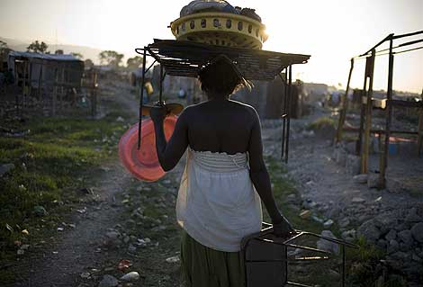 Una mujer haitiana carga con varios enseres en un campo de refugiados. | Efe