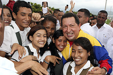 Chávez abraza a varios niños antes de encontrarse con Santos. | Reuters