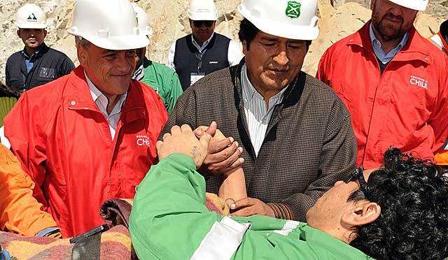 Evo Morales y Sebastián Piñera saludan al minero Víctor Zamora. | AP