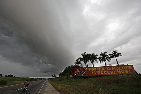 Una motocicleta recorre Piñar del Río. Sólo se ve un cartel, de la revolución. | Reuters