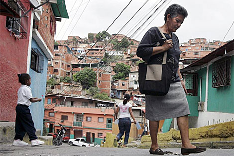 Una mujer camina por el barrio de Petare, en los suburbios de Caracas.