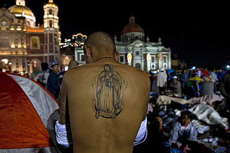 Un peregrino muestra su tatuaje de la Virgen de Guadalupe. | AFP