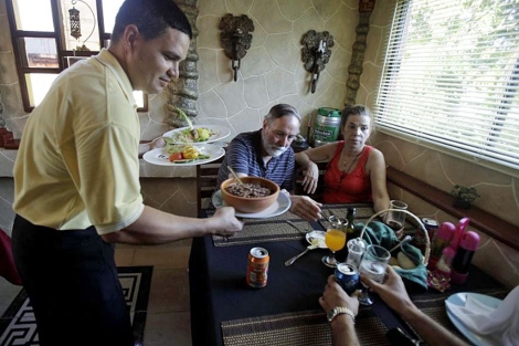 Un empleado sirve a sus clientes en un restaurante privado en La Habana. | AP