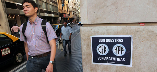 Un hombre pasa cerca de un cartel que reclama las petroleras como argentinas. | Efe