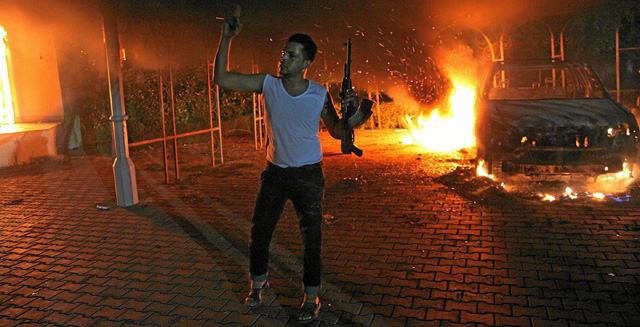 Un hombre armado ante el incendio del consulado en Bengasi, en el que murió el embajador. | Afp