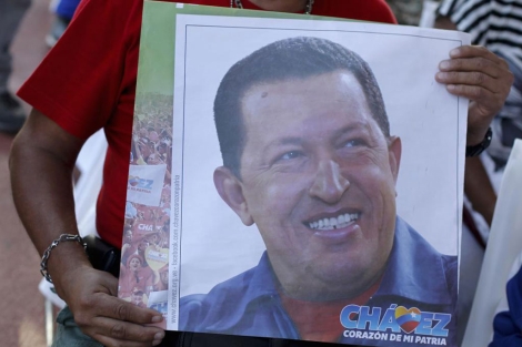 Un seguidor de Chávez sujeta una foto suya.| Reuters