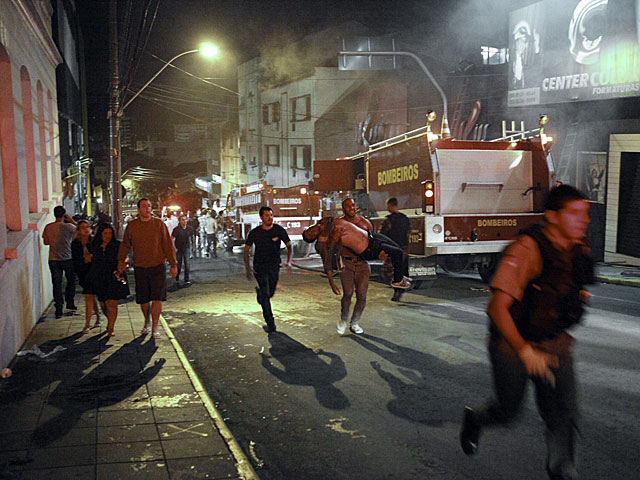 Los bomberos desalojan a los heridos de la discoteca Kiss.| Efe | Germano Rorato | VEA MÁS IMÁGENES