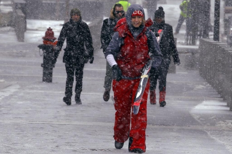 Una mujer camina por Boston cargando con sus skis. | Reuters
