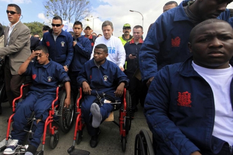 El presidente de Colombia, Juan Manuel Santos, empuja a un soldado herido. | Reuters