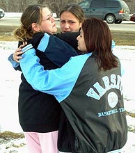 Tres menores se abrazan tras la matanza en su escuela de Minnesota. (Foto: AP)