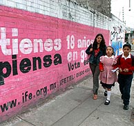 Una mujer y sus hijos pasan ante un cartel electoral. (Foto: EFE) Una mujer y sus hijos pasan ante un cartel electoral. (Foto: EFE)