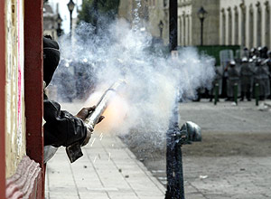 Un manifestante arroja cohetes a miembros de la polic�a. (Foto: REUTERS)