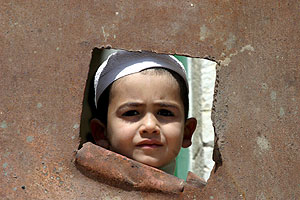 Un niño palestino mira por un hueco el control policial llevado a cabo en la ciudad de Hebrón. (Foto: EFE)