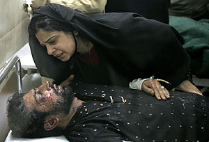 Una mujer con uno de los familiares heridos en el atentado que acab� con Bhutto. (Foto: EFE)