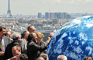 Pachauri firma un globo terr�queo en el segundo d�a de la reuni�n de ministros en Par�s. (Foto: AFP)