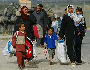 Refugiados iraquíes caminan después de pasar un puesto de control. (Foto: Kevin Frayer)