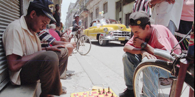 Dos cubanos juegan al ajedrez sobre el asfalto. (Foto: AP)