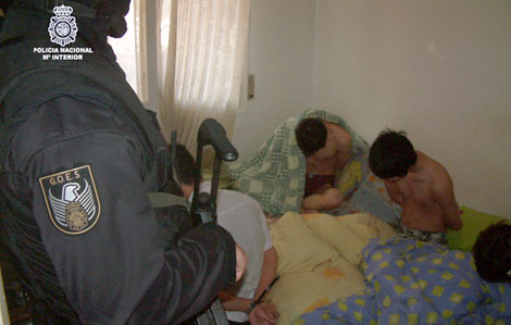 Un agente custodia a dos de los detenidos durante la operación | CNP