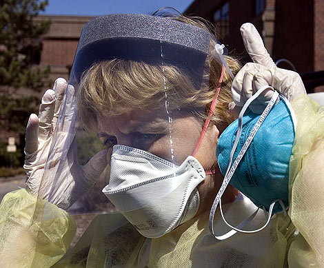 Una enfermera se tapa la boca con una mascarilla. | Ap