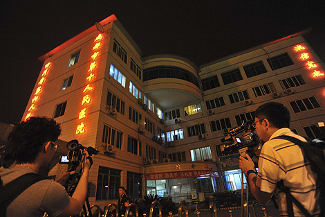 Dos periodistas chinos graban el hospital de Sichuan donde está aislado el primer caso de gripe porcina en el país. | AP