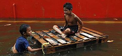 Unos niños juegan con el agua.| Reuters VEA MÁS FOTOS