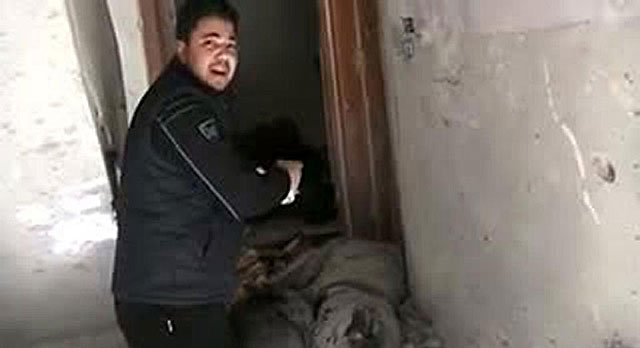 Un vecino del barrio de Bab Amro, en Homs, muestra supuestamente el cadáver de un periodista. | Afp