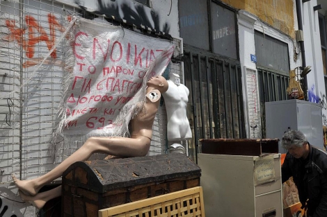 Maniquíes abandonados en un edificio con el cartel de 'Se alquila', en Atenas. | Afp