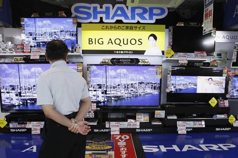Un hombre observa los televisores de fabricante 'Sharp'. | Reuters