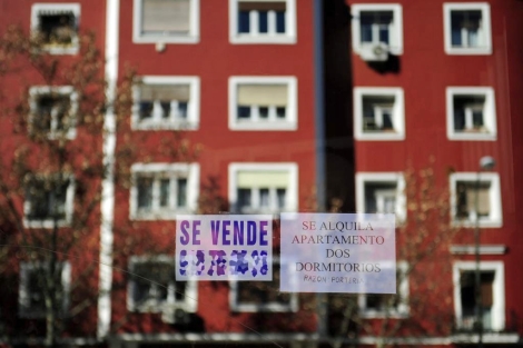 Carteles que anuncian la venta y alquiler de dos viviendas en Madrid. | B. Díaz