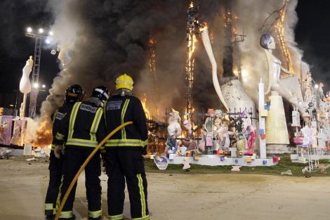 Tres bomberos durante la cremà de una falla en Valencia. | Benito Pajares