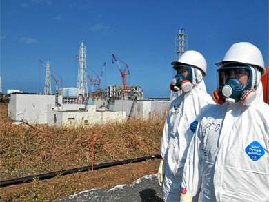 Varios operarios con trajes de protección en la planta de Okuma. | Afp