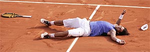 Nadal se tumba sobre la arena de París tras ganar a Federer en la final de Roland Garros 2005. (Foto: AP)