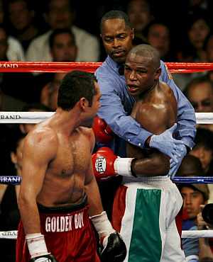 Mayweather es sujetado por el árbitro en un momento del combate ante Óscar de la Hoya. (Foto: EFE) Mayweather es sujetado por el árbitro en un momento del combate ante Óscar de la Hoya. (Foto: EFE)