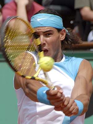 Rafael Nadal devuelve la pelota al francés Fabrice Santoro durante el partido de exhibición que jugaron en la pista 'Philippe Chatrier' en el marco de Roland Garros. (Foto: EFE)
