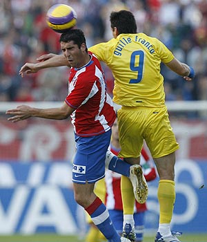Raúl García pelea un balón por alto con Guille Franco. (Foto: EFE)