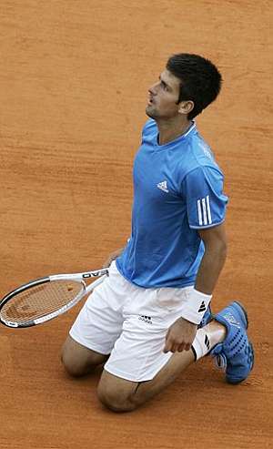 Novak Djokovic, sorprendido por un punto de nadal, hinca la rodilla en tierra. (AFP)