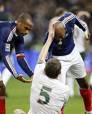 Henry y Anelka ayudan a levantar al desolado Richard Dunne. | AFP Henry y Anelka ayudan a levantar al desolado Richard Dunne. | AFP