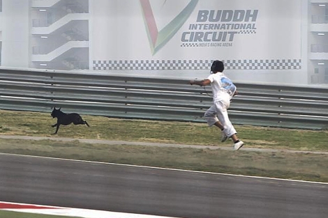 Un operario persigue a un perro en el circuito. | Reuters