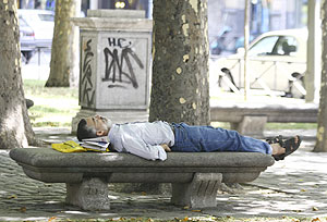 Un hombre duerme sobre un banco