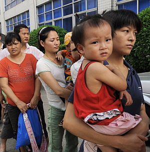 Varios padres chinos acuden con sus hijos a una revisión por el caso. (Foto: REUTERS)