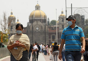 Una pareja mexicana con 'tapabocas' en la iglesia de Guadalupe. (Foto: EFE)