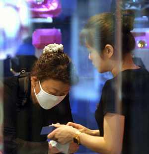 Una dependienta con mascarilla en Beijing. (Foto: AFP
