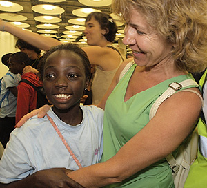 Ana de Pablos recibe a una niña de acogida en el aeropuerto (Foto: Infancia Solidaria)