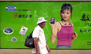Un hombre pasea delante de un anuncio de reproductores de MP3 en China. (Foto: AP)