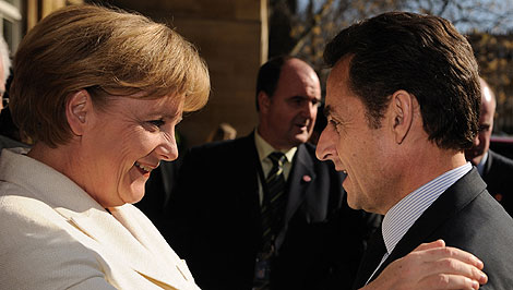 Merkel y Sarkozy se saludan antes de su reunión en Londres. | AFP